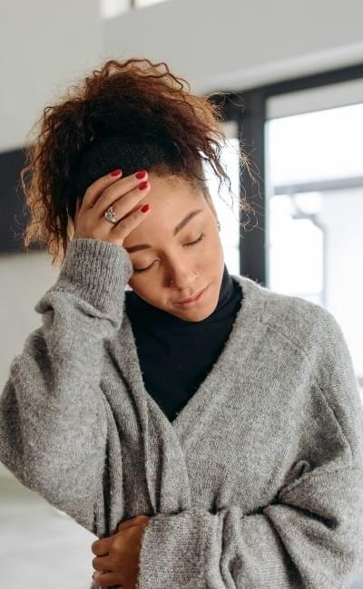 woman holding head in pain